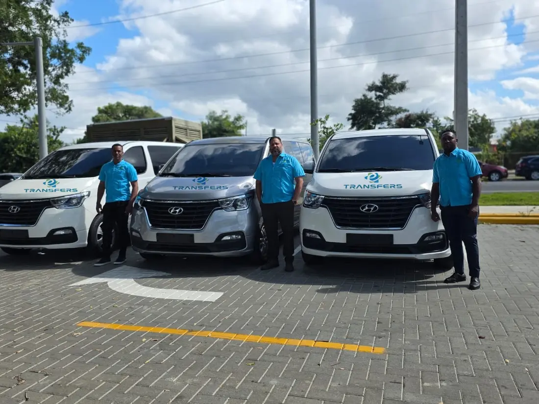 Three eTransferSDQ drivers in blue shirts next to their minivans