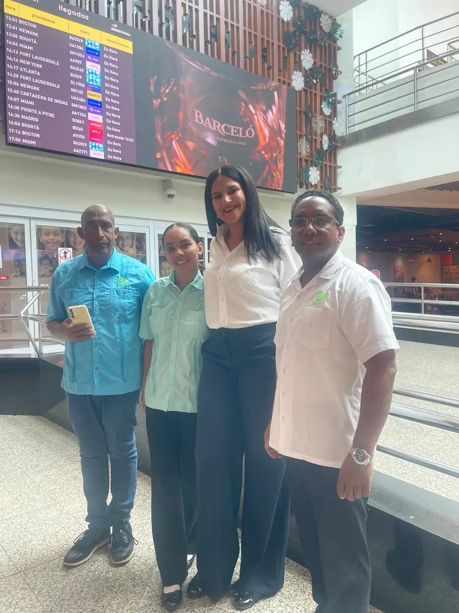 eTransferSDQ team in the arrivals hall at Las Américas Airport, under the arrivals board